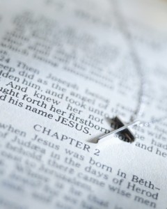 A plain cross lies on a Bible, at the beginning of the second chapter of the Gospel of Matthew, describing the birth of Jesus.